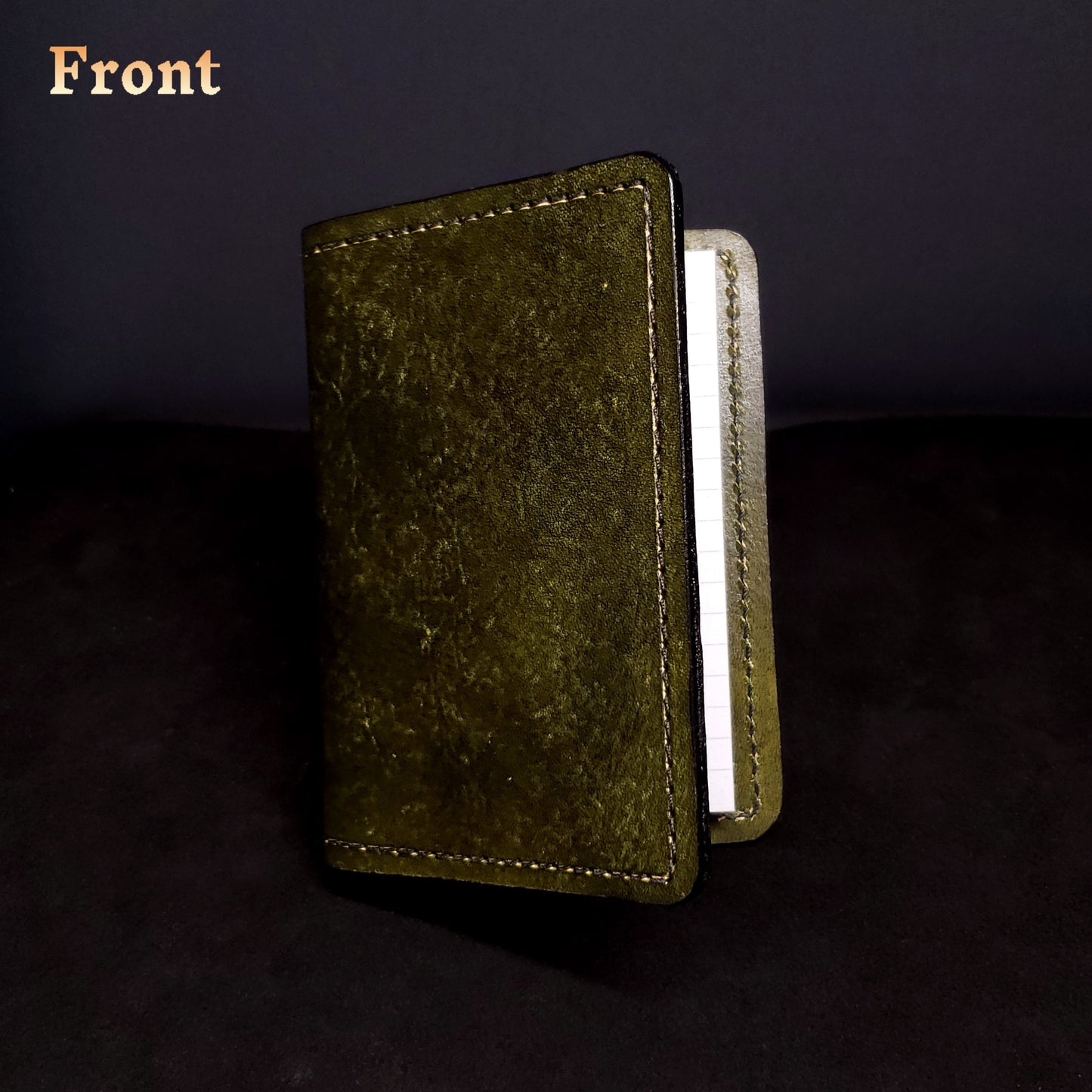 Olive-green leather mini-composition cover, closed and viewed from the front
