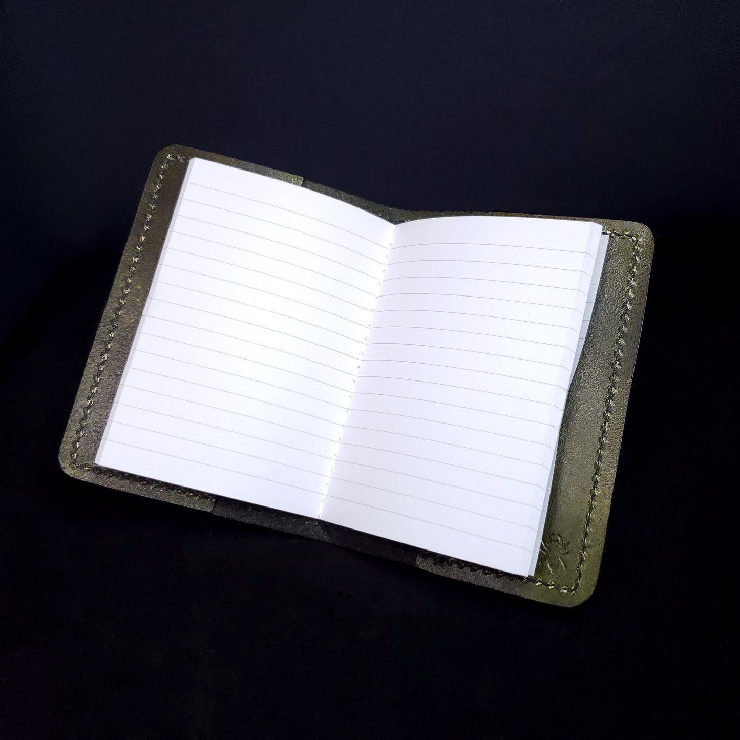 Olive-green leather mini-composition cover, opened with lined ages
