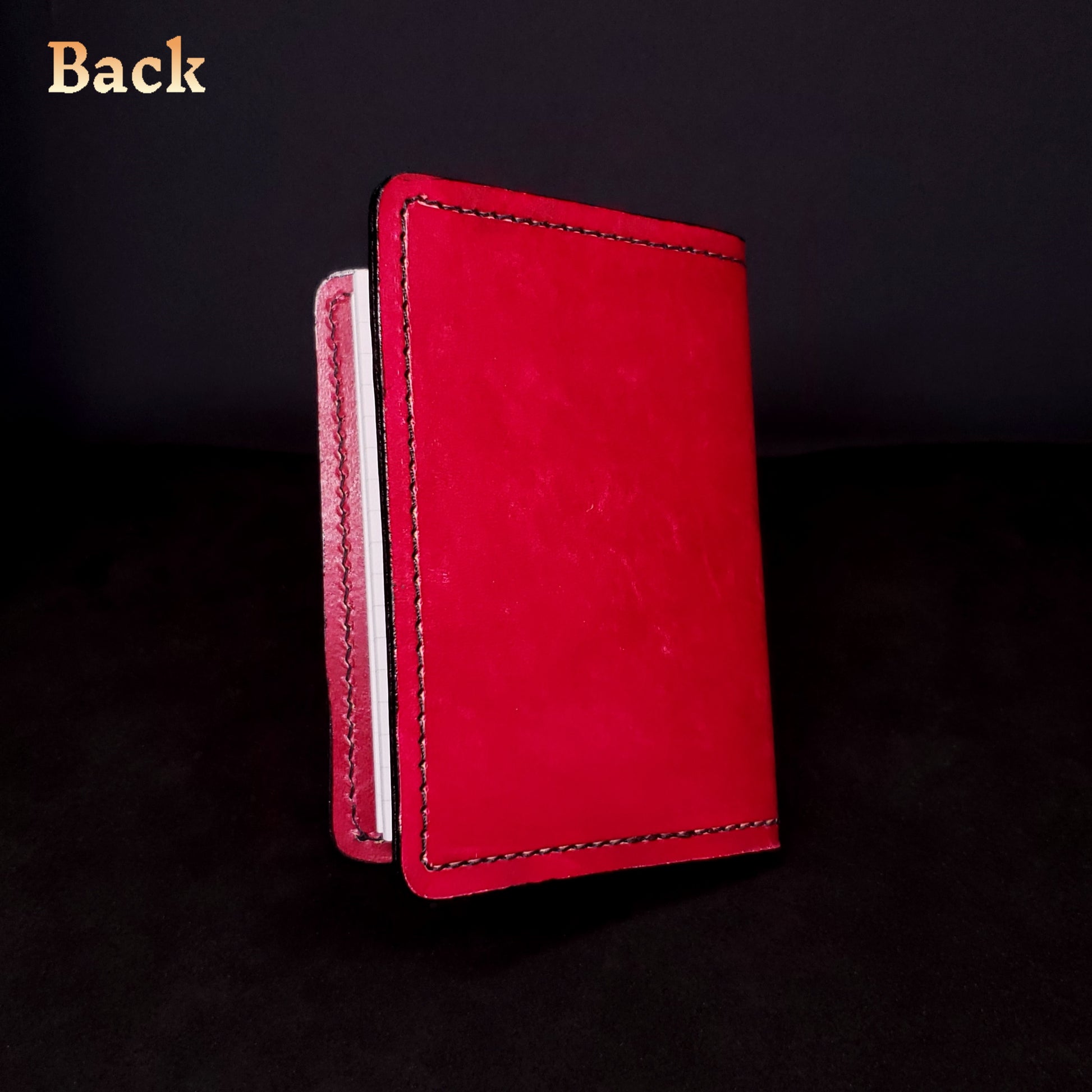 Red leather mini-composition cover, closed and viewed from the back.