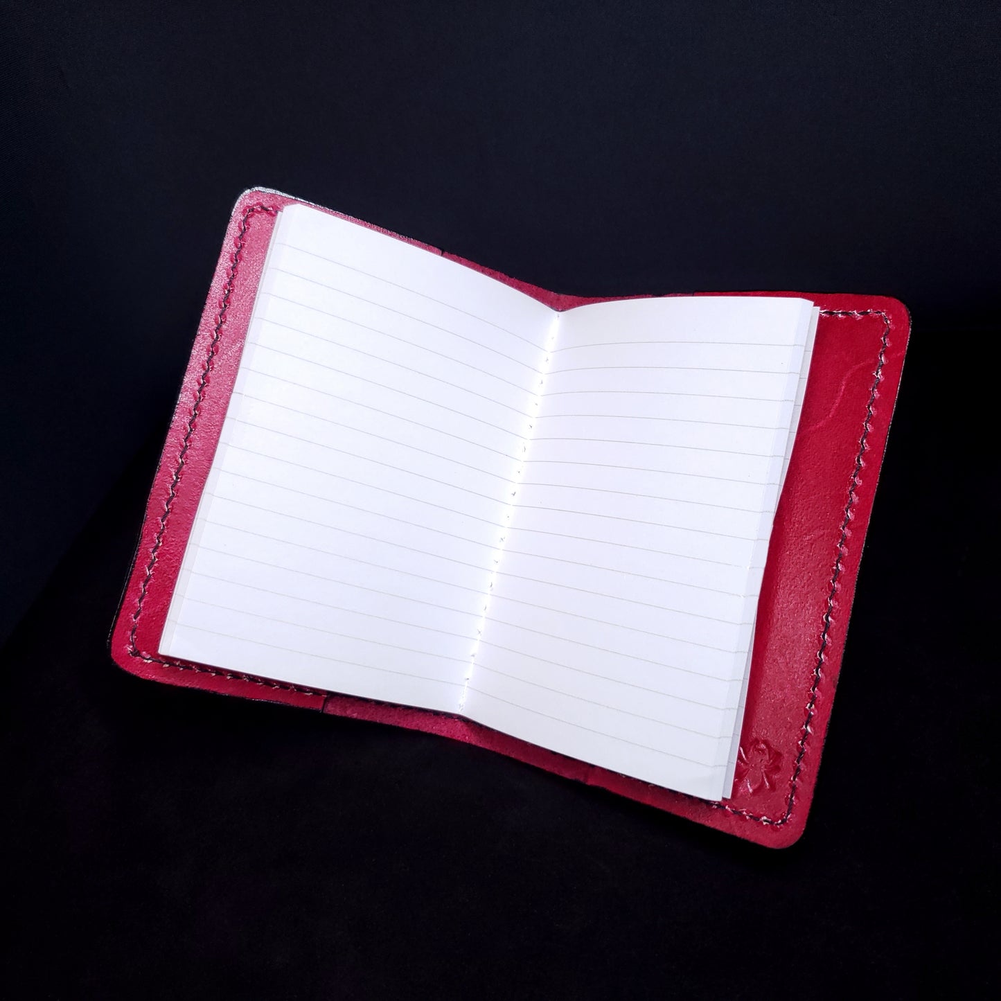 Red lether mini-composition cover, opened with lined pages.