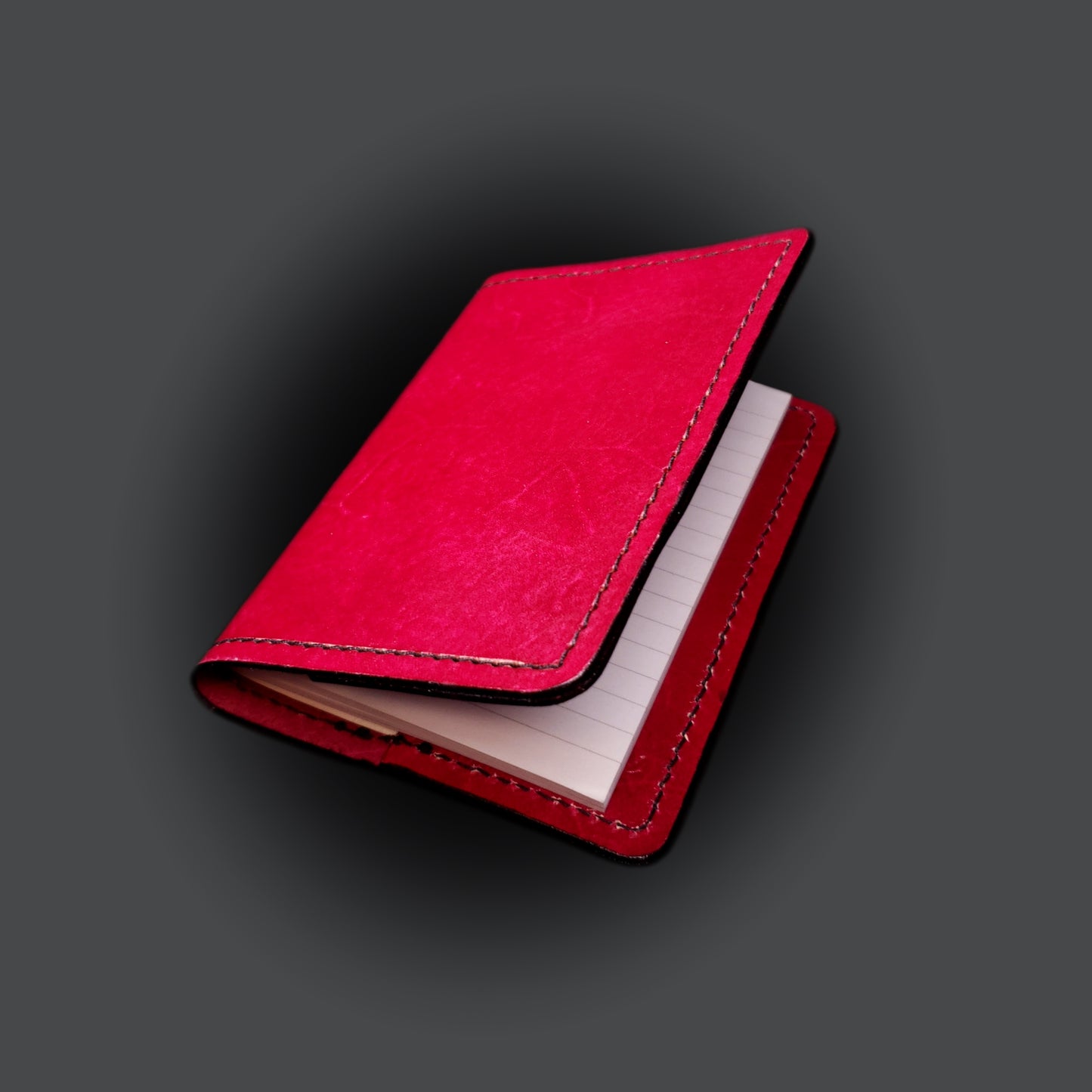 Red leather mini-composition cover on a grey background.