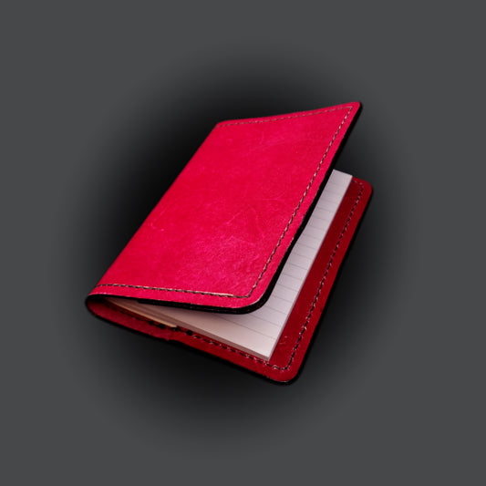 Red leather mini-composition cover on a grey background.