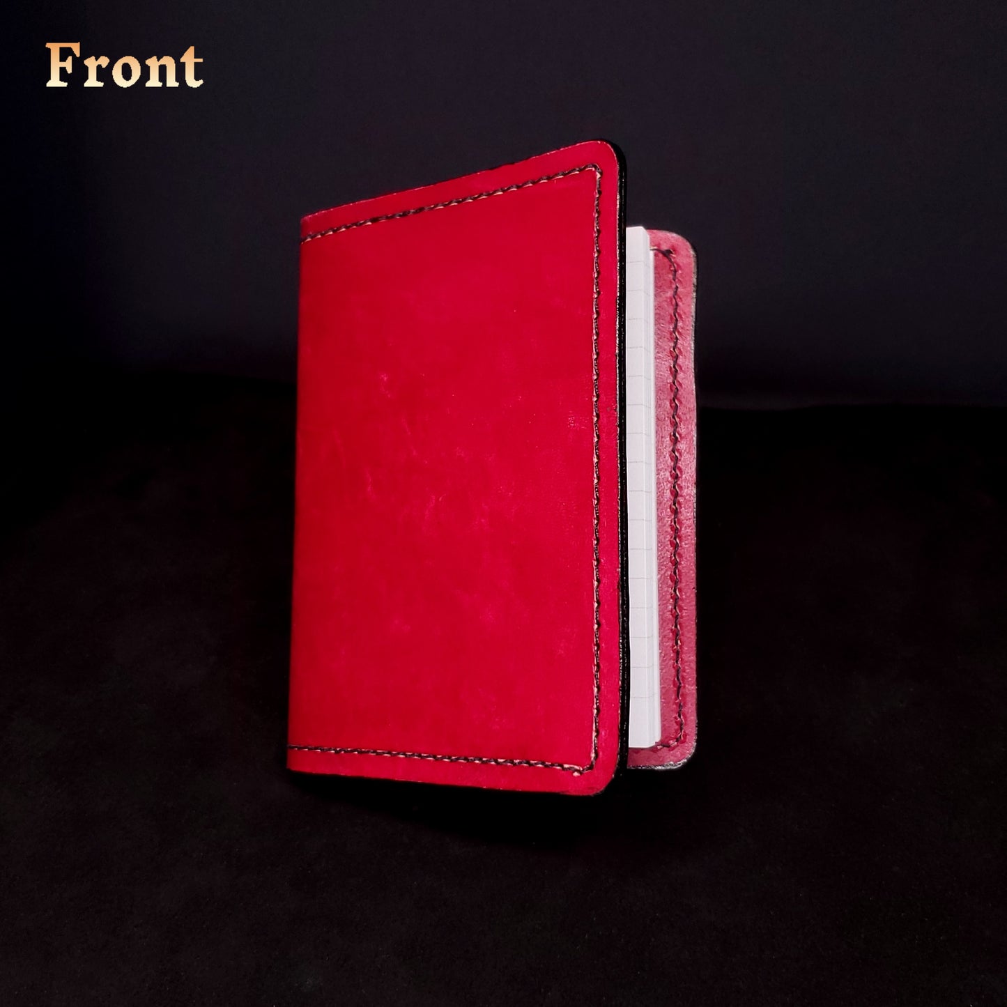 Red leather mini-composition cover, closed and viewed from the front.