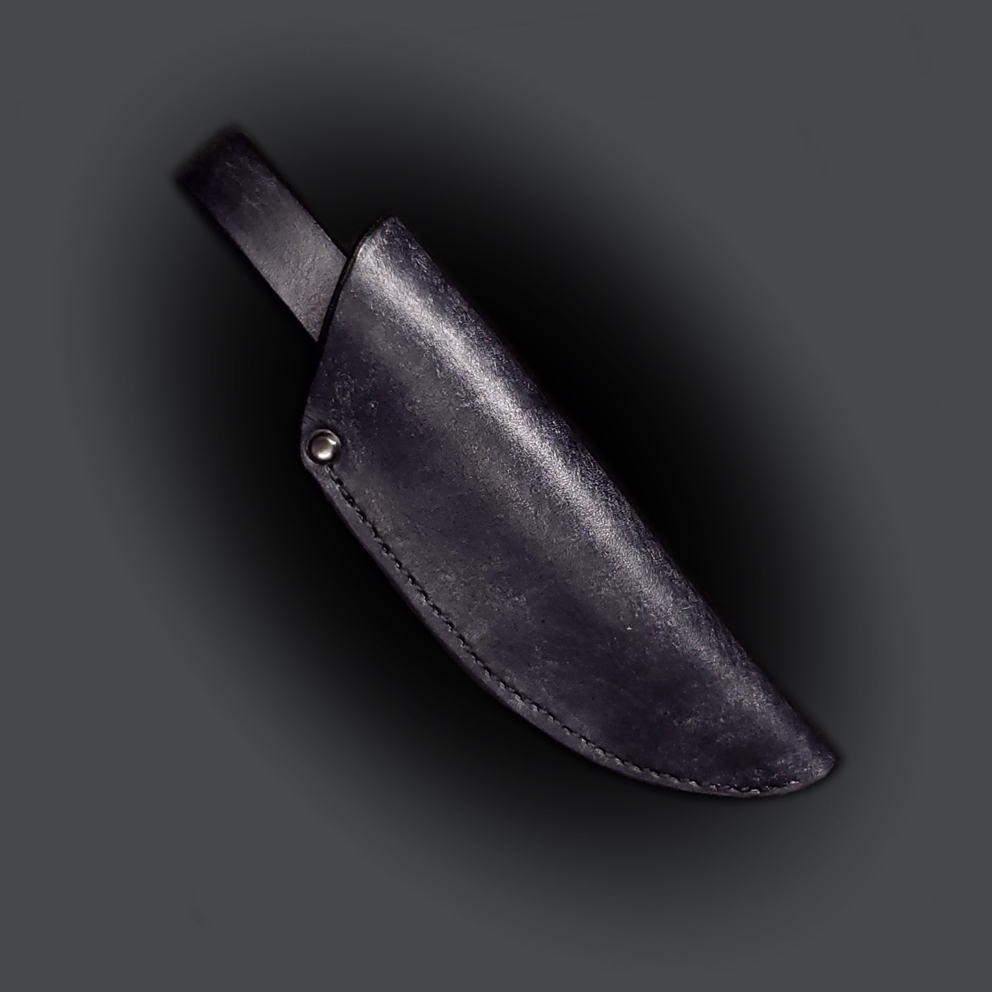 Black leather knife sheath on a grey background.