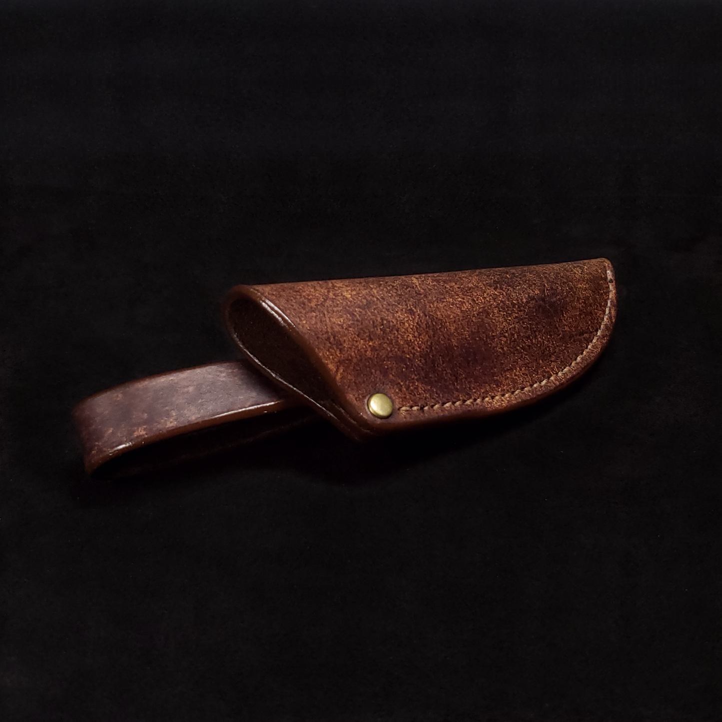 Brown leather knife sheath, viewed down its length from its opening.
