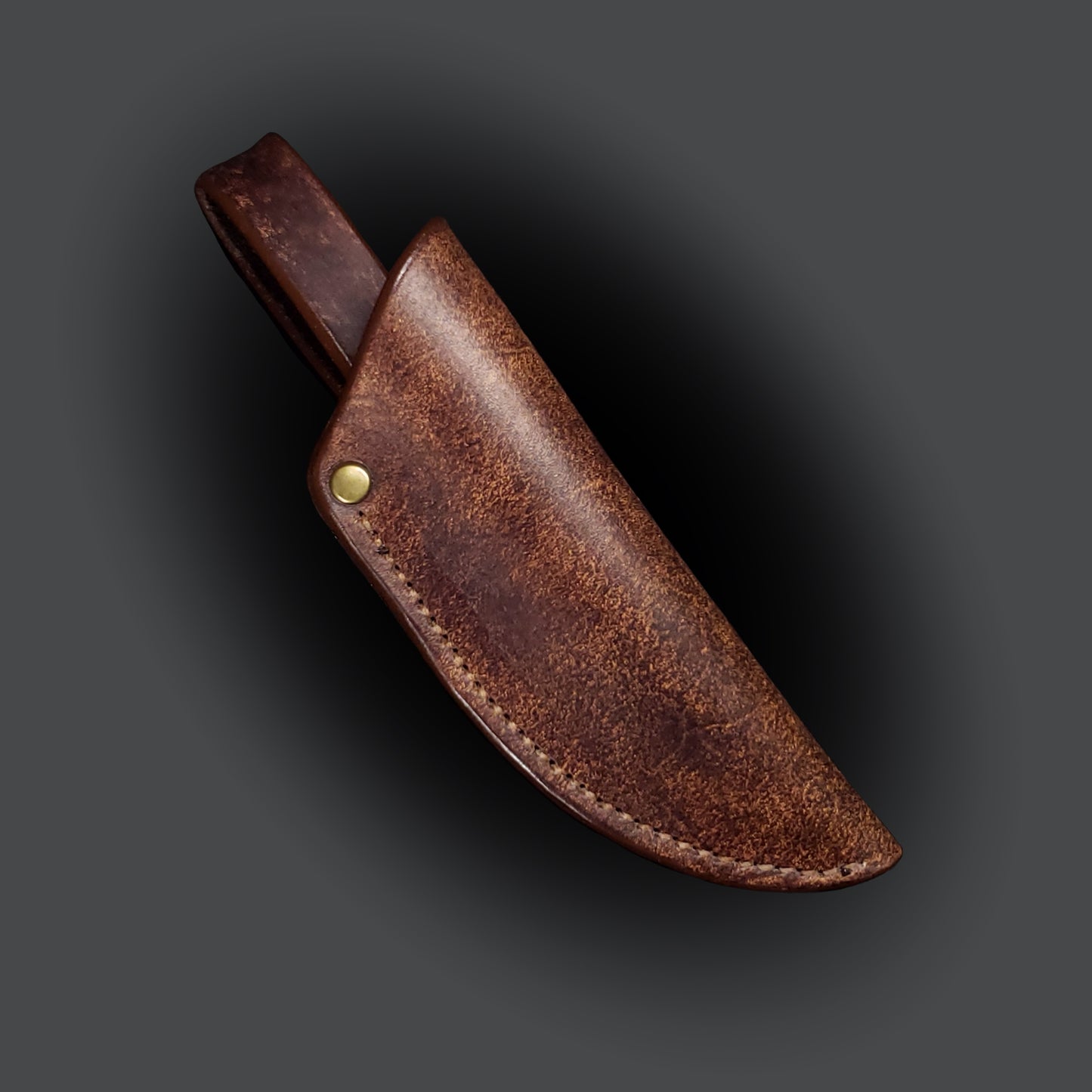 Brown leather knife sheath on a grey background.