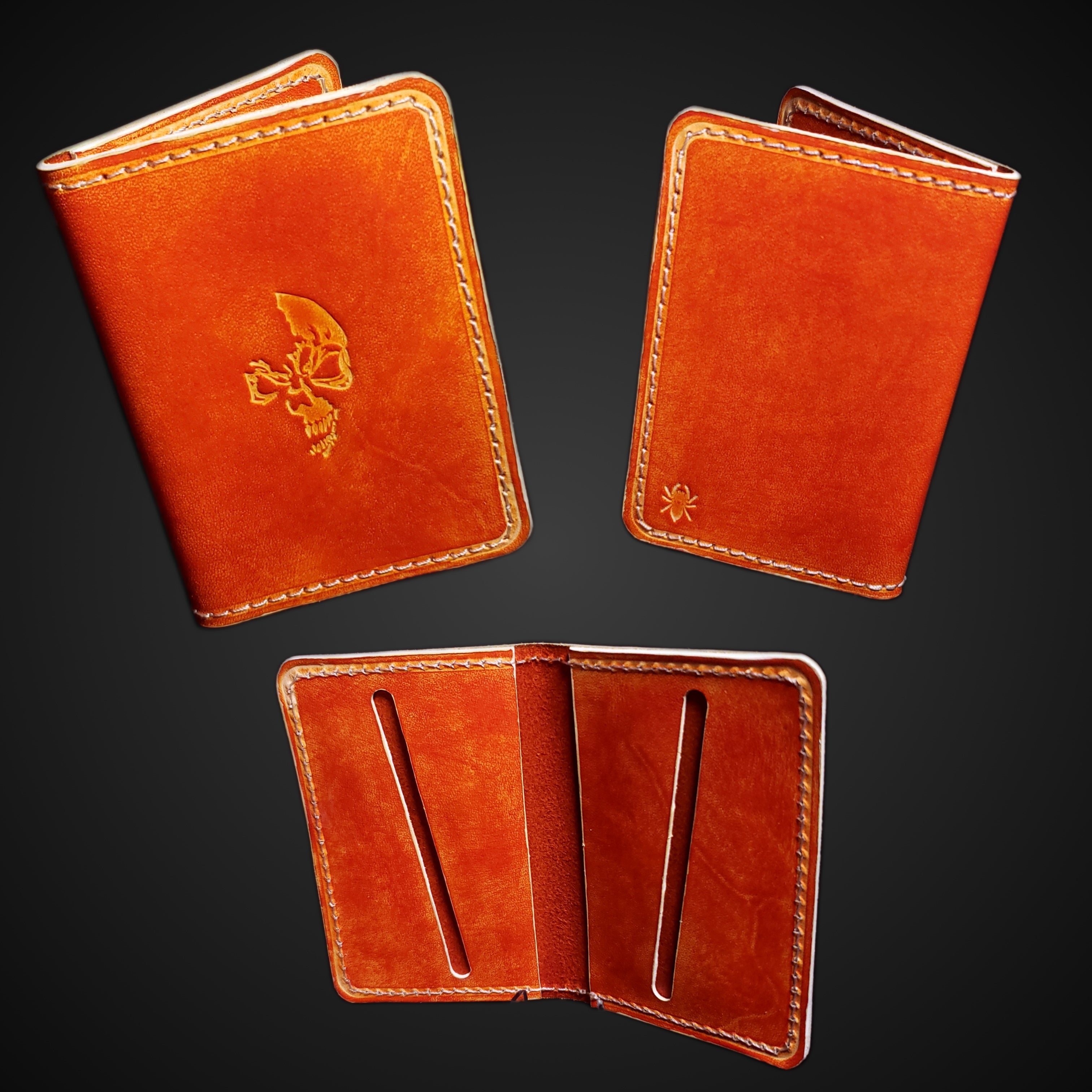 An orange and white leather card wallet embossed with a skull, viewed from different angles.