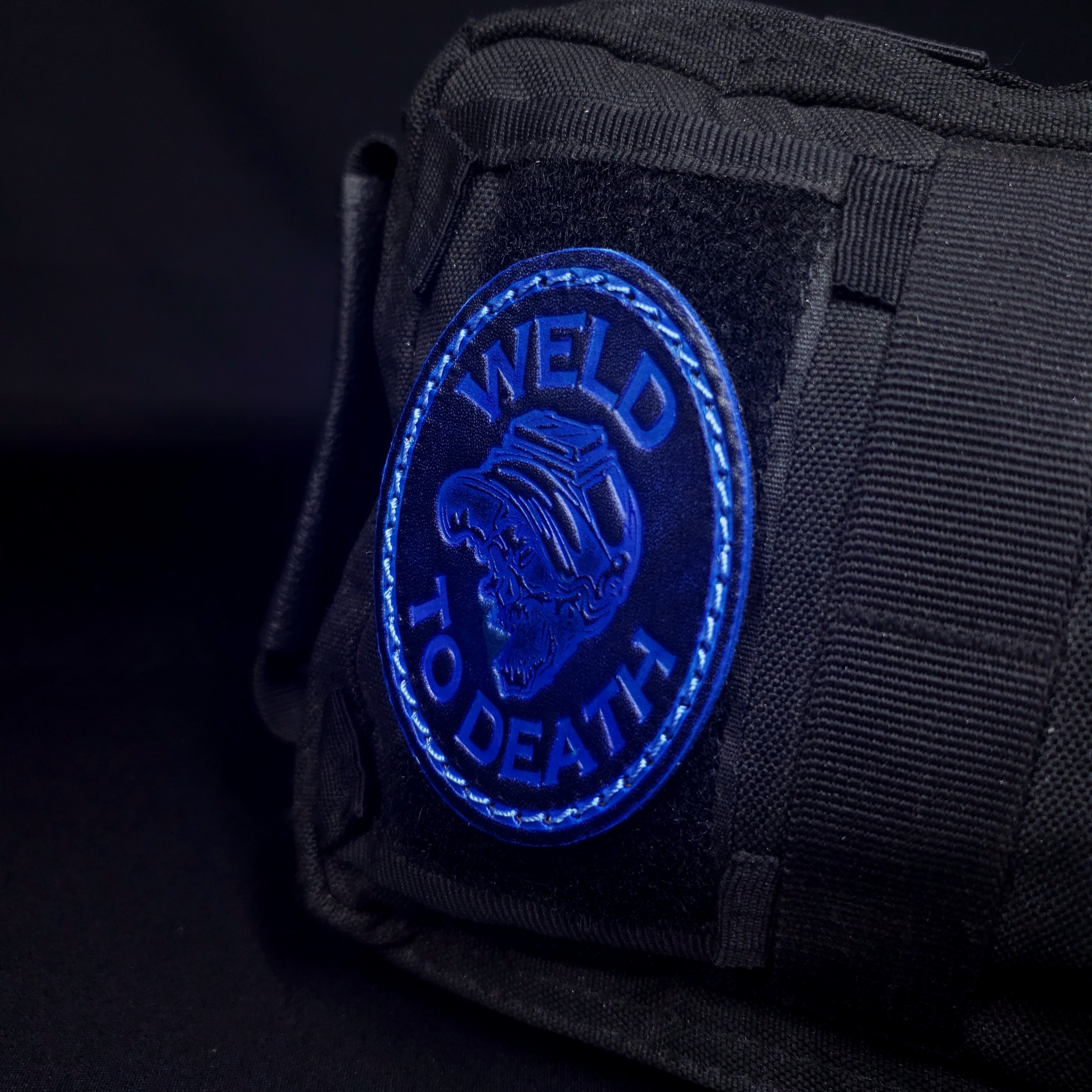 Black and blue leather velcro patch with a graphic of a skull wearing a welding hood.